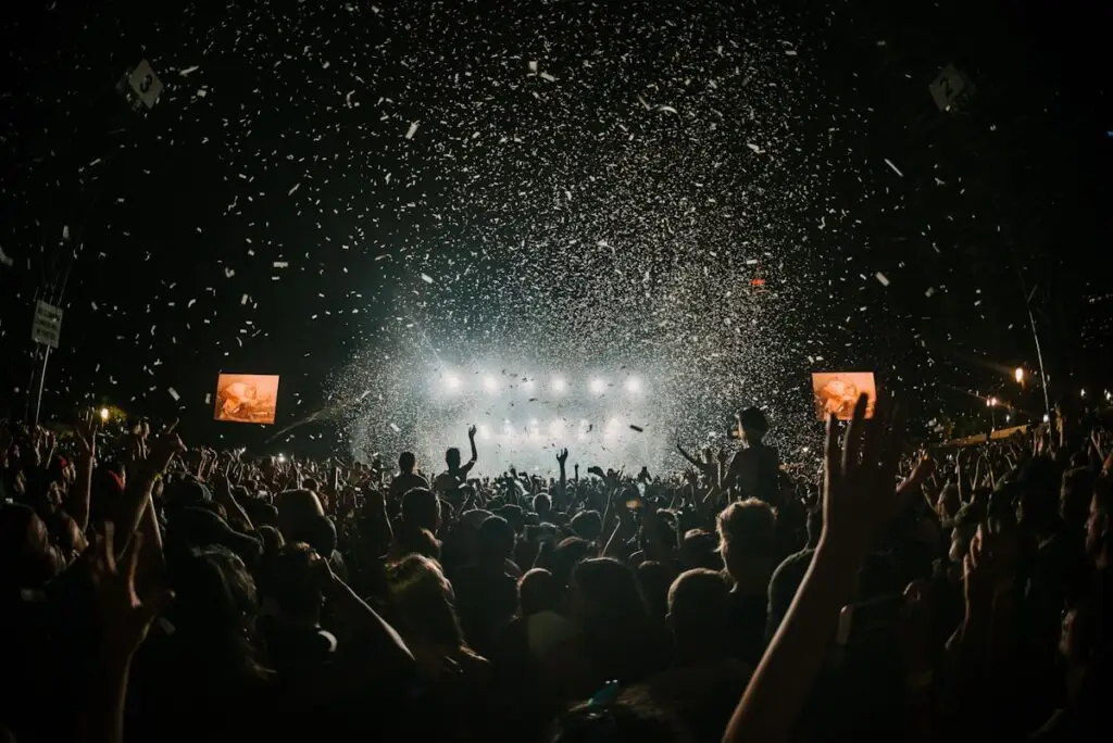 Outdoor music festival crowd with hands raised at a daytime indie festival