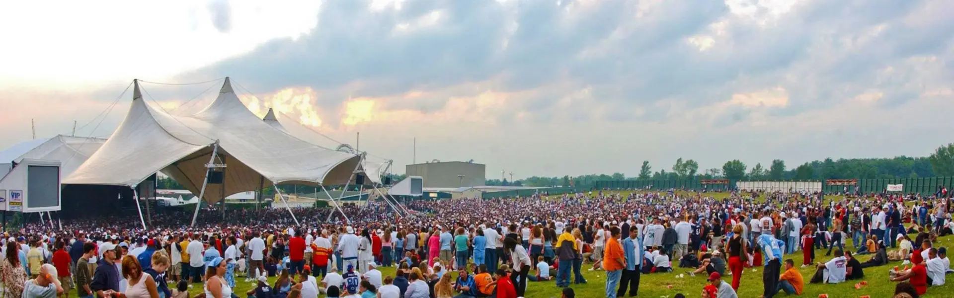 Darien Lake Amphitheater lawn crowd during a summer concert with the tent pavilion visible at sunset
