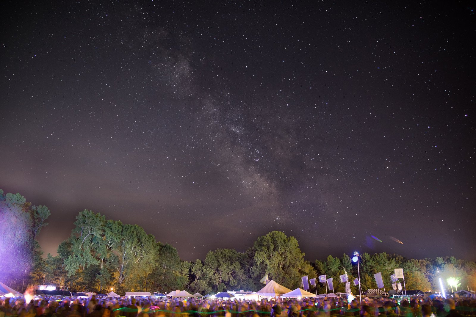 Festival crowd gathered under the Milky Way at the Finger Lakes GrassRoots Festival in Trumansburg, New York