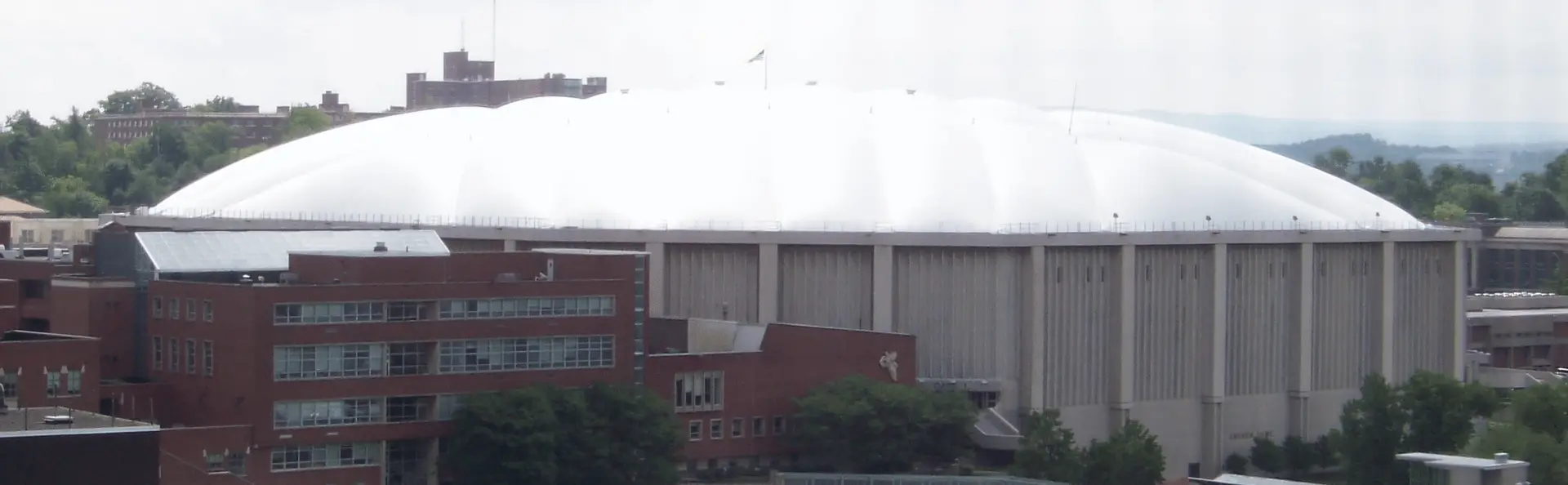 Exterior aerial view of JMA Wireless Dome at Syracuse University showing the iconic white dome roof and surrounding campus buildings