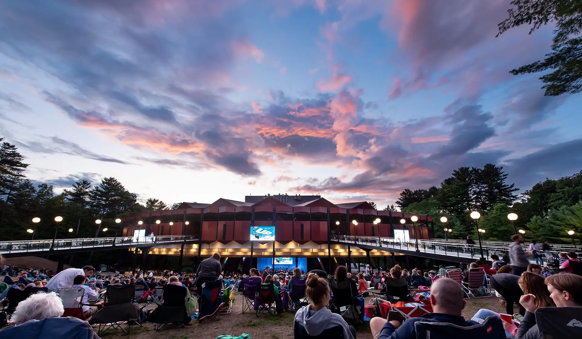 Saratoga Performing Arts Center amphitheater and lawn at sunset surrounded by pine trees in Saratoga Spa State Park