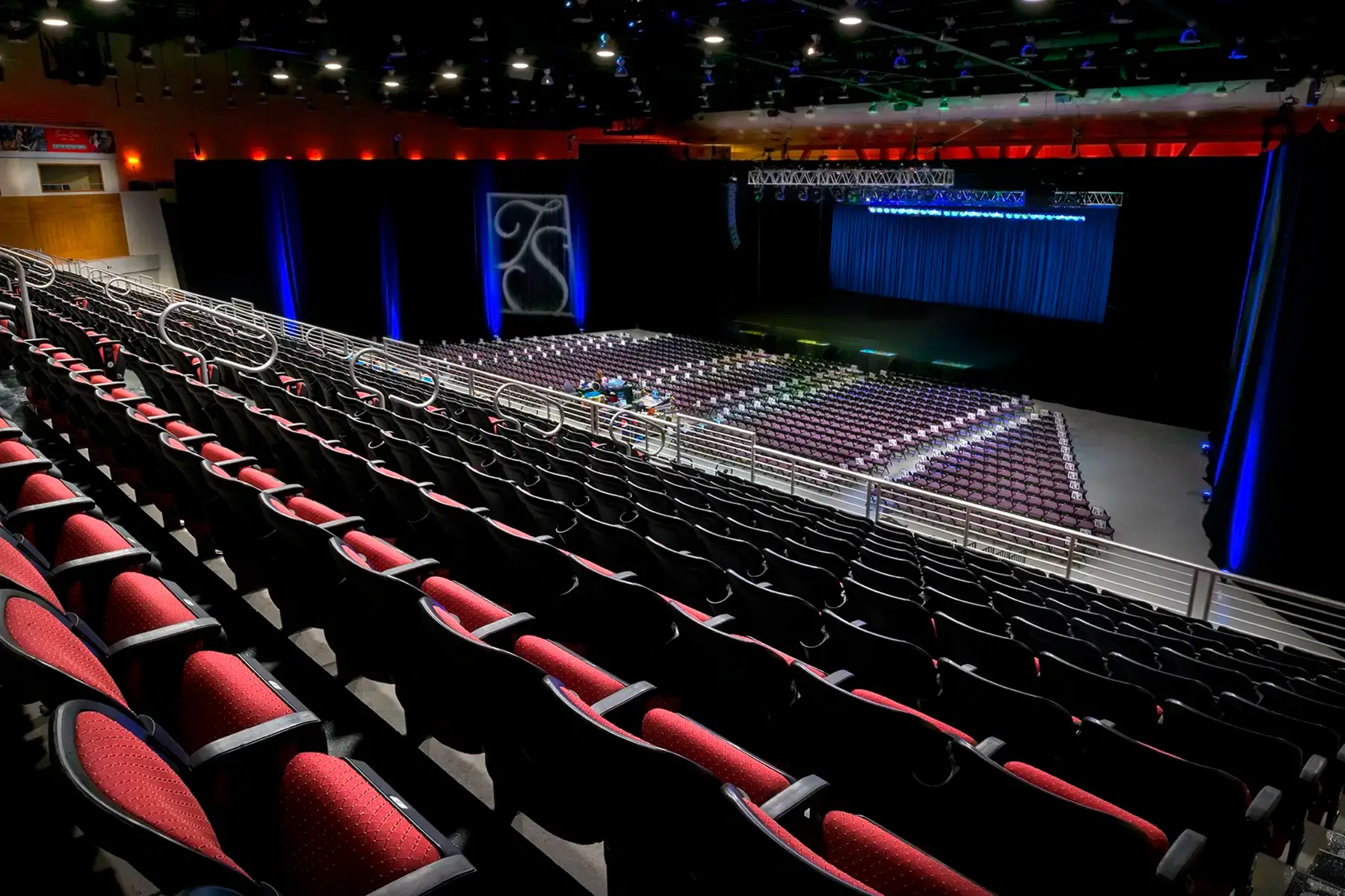Turning Stone Event Center interior showing tiered red seating and stage area with blue accent lighting