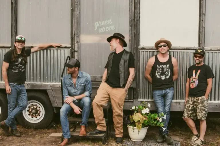 The Mallett Brothers Band posed outside a green room backstage at an outdoor venue