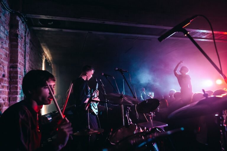 Young band performs on stage in an intimate brick-walled music venue with stage lighting
