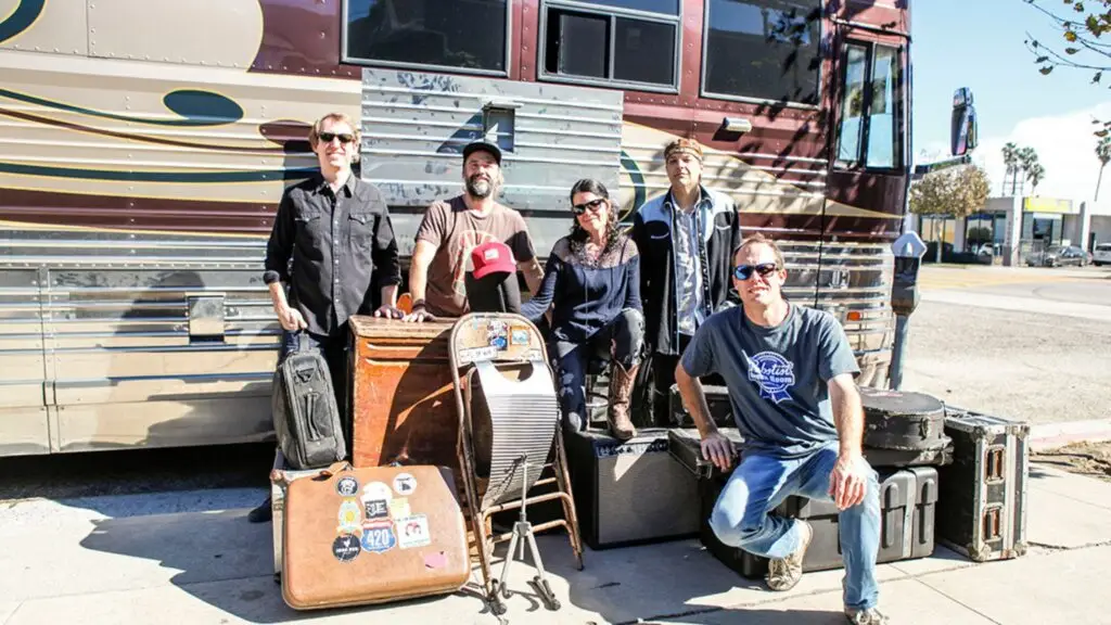 Donna the Buffalo band members pose in front of their tour bus with road cases