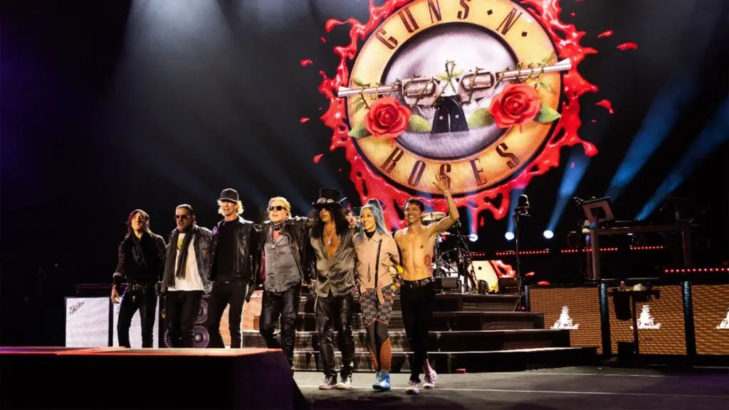 Guns N' Roses full band lineup on stage with iconic bullet logo backdrop during 2026 World Tour