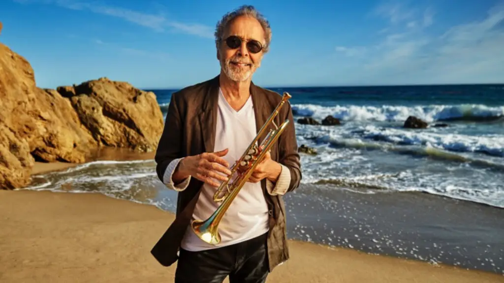 Herb Alpert holds his trumpet on a beach during his 60th anniversary Tijuana Brass tour
