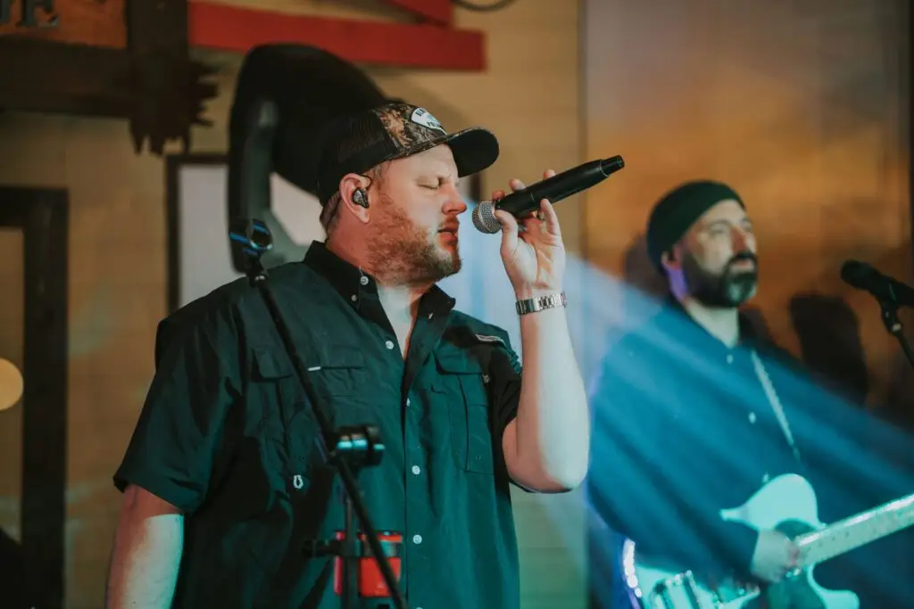 Luke Combs UK tribute band frontman performing live on stage with microphone
