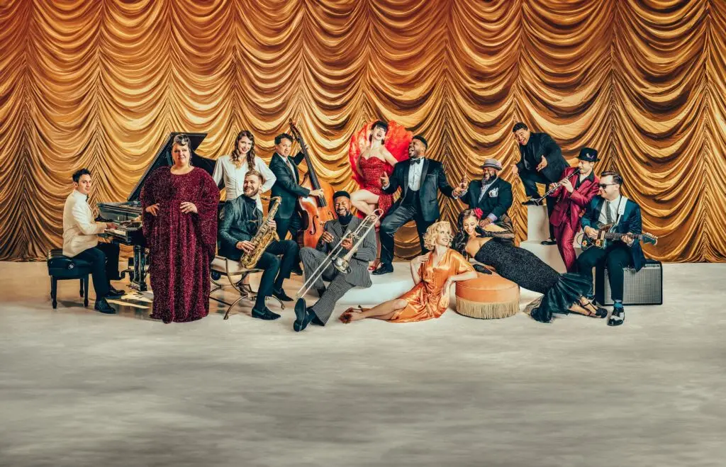 Scott Bradlee's Postmodern Jukebox ensemble in vintage attire performs live on stage