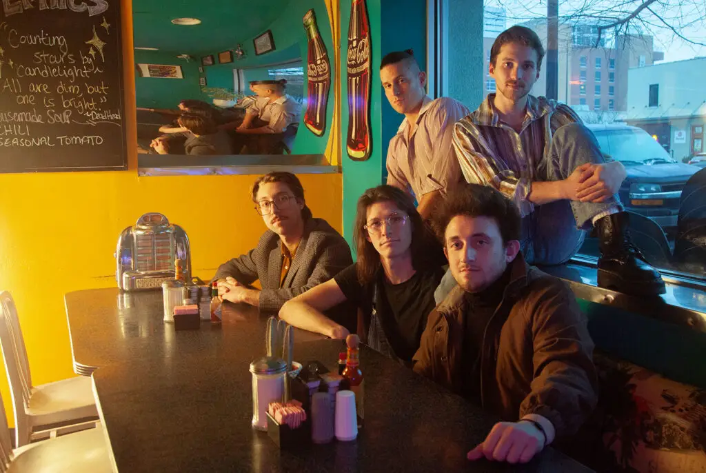Post Sex Nachos band members pose together at a diner, press photo by Megan Casady