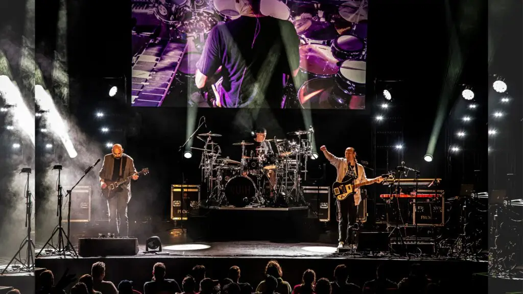 The Rush Tribute Project performing live on stage with video screens and stage lighting