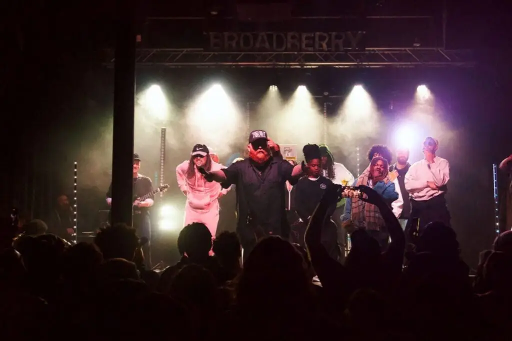 Chandler performs at The Broadberry in Richmond, arms spread wide on stage under concert lighting