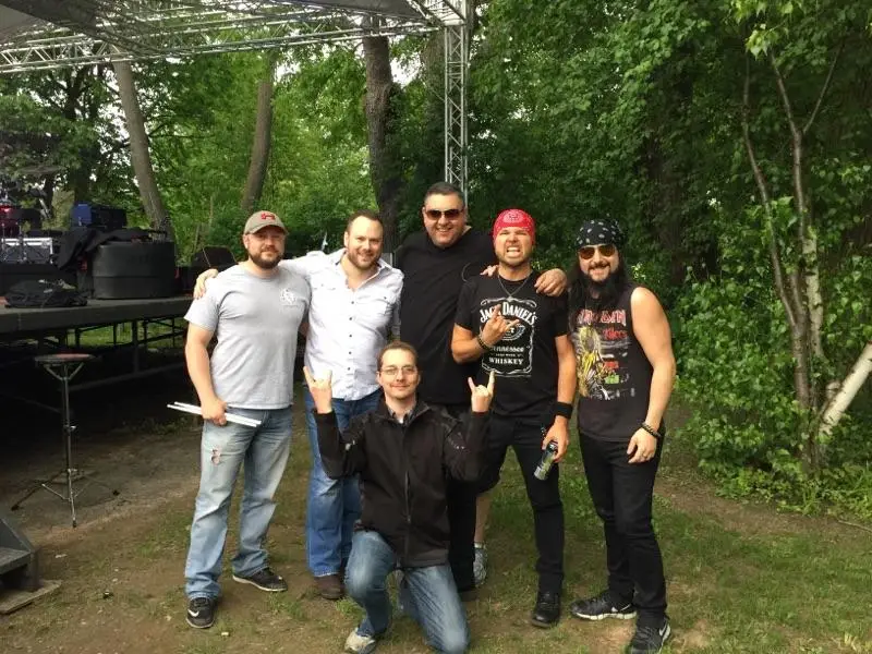Scars N Stripes band members pose near outdoor stage before a show