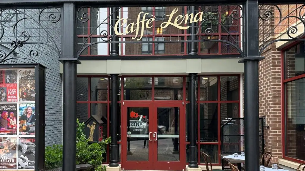The entrance to Caffè Lena at 47 Phila Street in Saratoga Springs, beneath a wrought-iron arch bearing the venue name