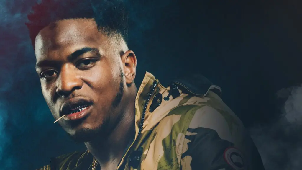 Niska, French rapper, in a dramatic promotional portrait wearing a camo jacket