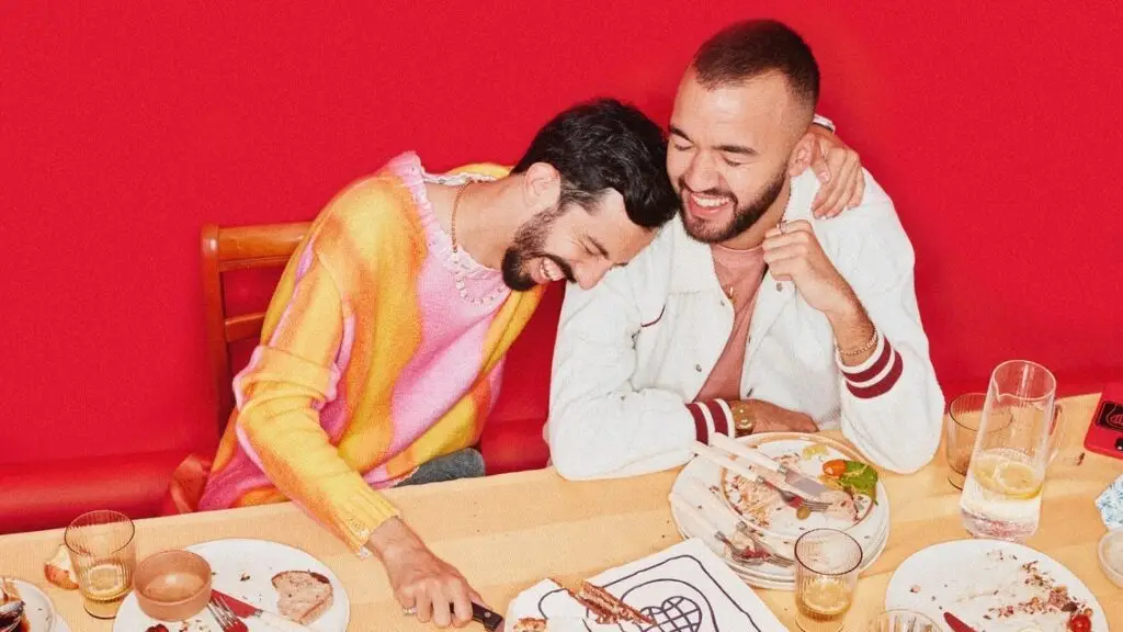 Bigflo & Oli posed at a dining table in an official Karma Tour promotional photo