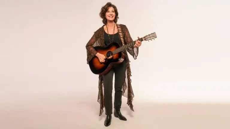 Amy Grant with acoustic guitar, promotional press photo for The Me That Remains tour 2026
