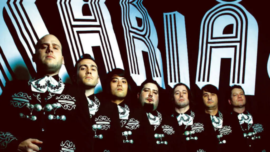 Mariachi El Bronx performing in matching black charro suits in front of band backdrop