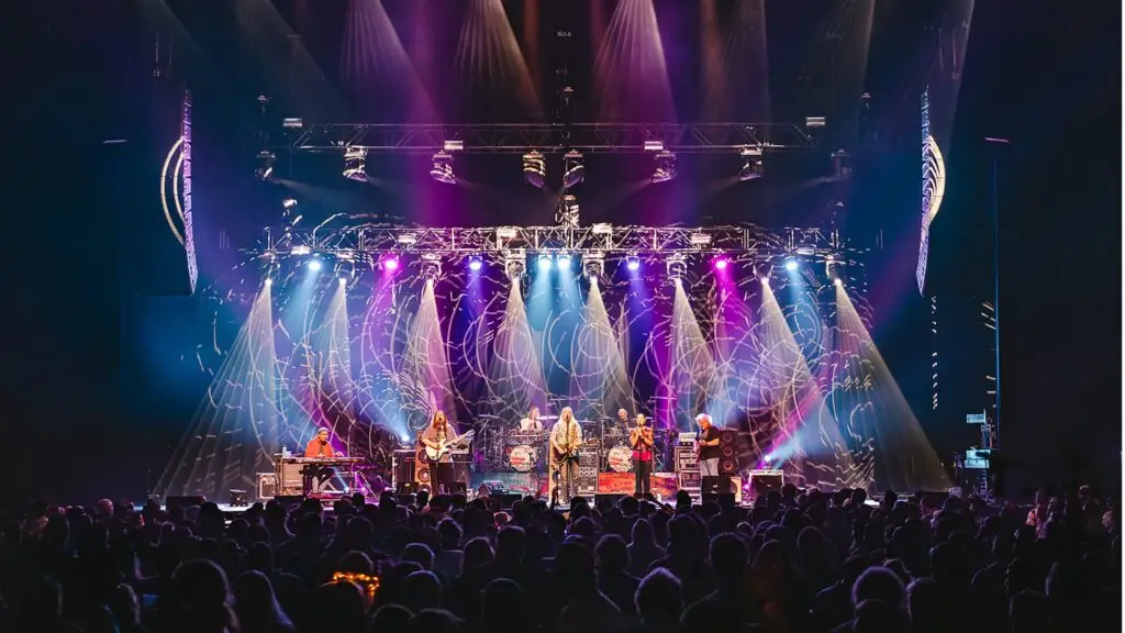 Dark Star Orchestra performing live on stage with psychedelic light show and full crowd