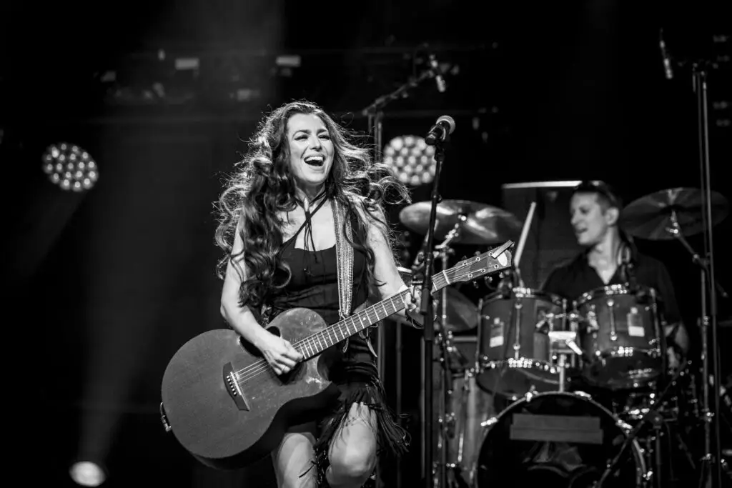 Jessica Lynn performing live on stage with guitar, black and white concert photo