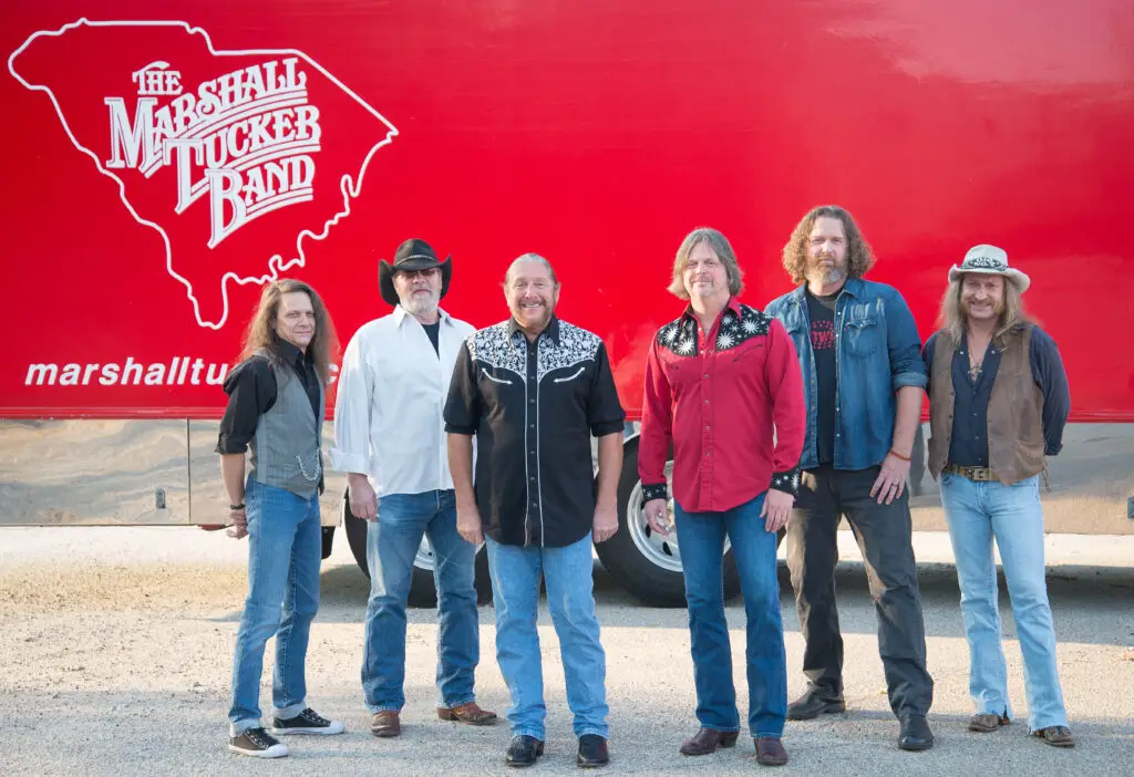 The Marshall Tucker Band poses in front of their red tour truck