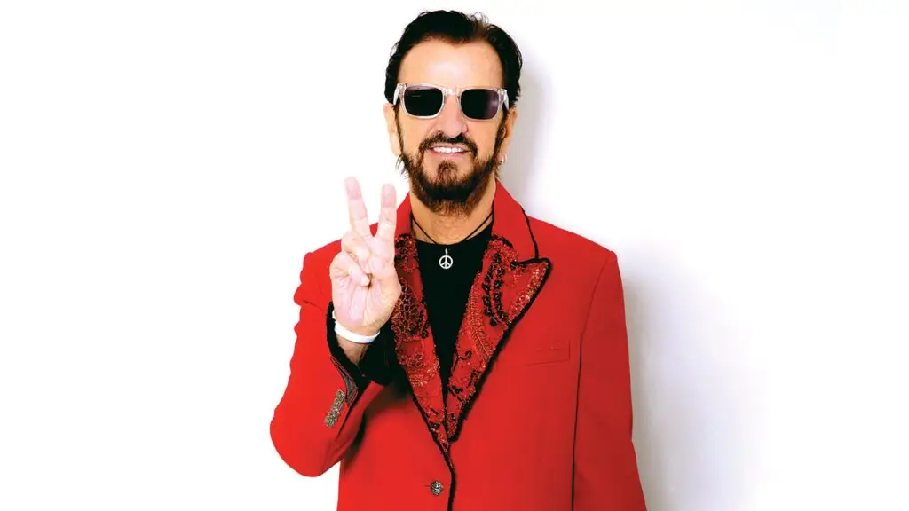 Ringo Starr makes a peace sign in his red sequined jacket — official 2026 promotional photo