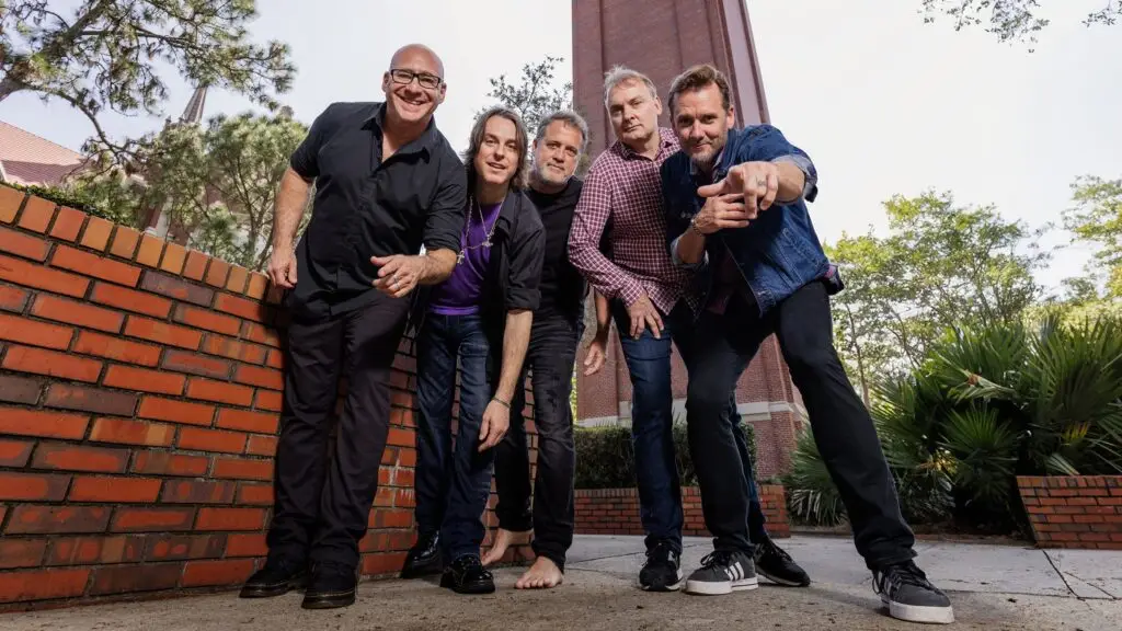 Sister Hazel band members posing together against a brick wall on the University of Florida campus in Gainesville