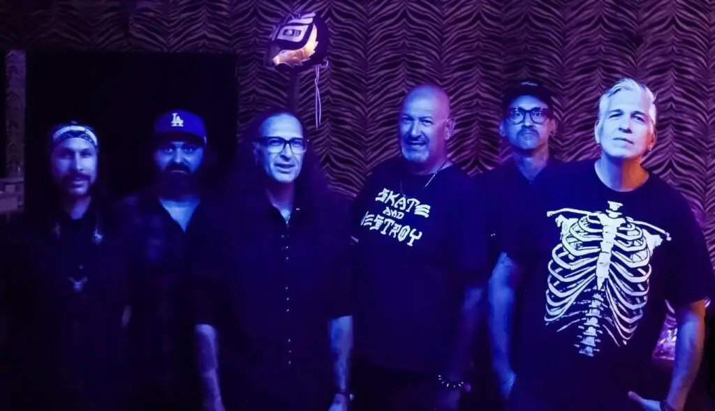 VooDoo Glow Skulls six-piece skacore band in their 2024 press photo at a venue with purple stage lighting