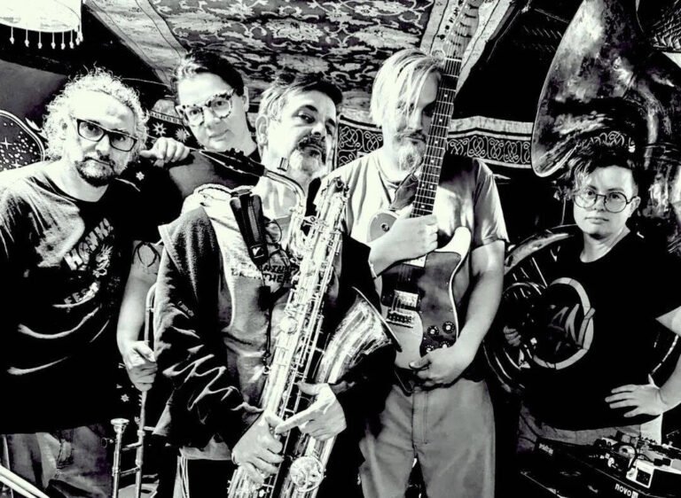 Eight Foot Manchild band members with tuba, trombone, saxophone, and guitar in B&W press photo