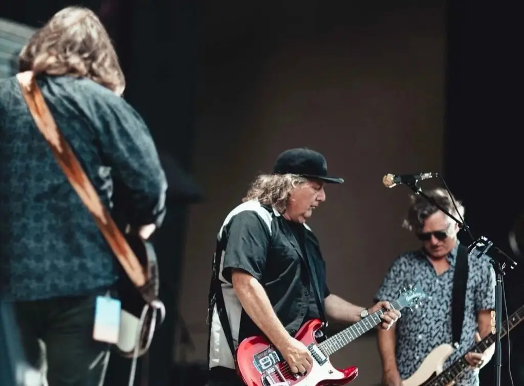 Drivin N Cryin performing live — Kevn Kinney on guitar and vocals at center mic with bassist and drummer