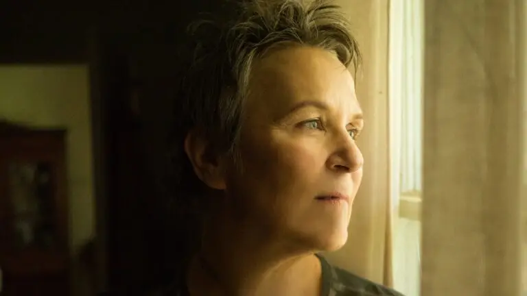Mary Gauthier, singer-songwriter, in a contemplative portrait gazing out a window