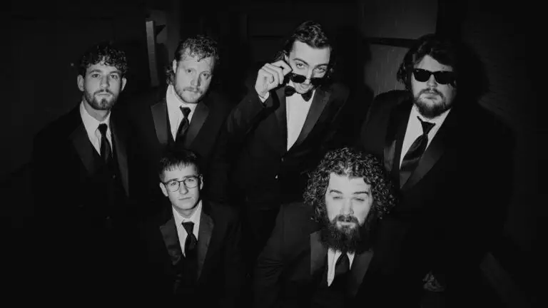 Ole 60 band members in formal suits pose for a B&W press photo, Outer Harbor Live at Terminal B Buffalo