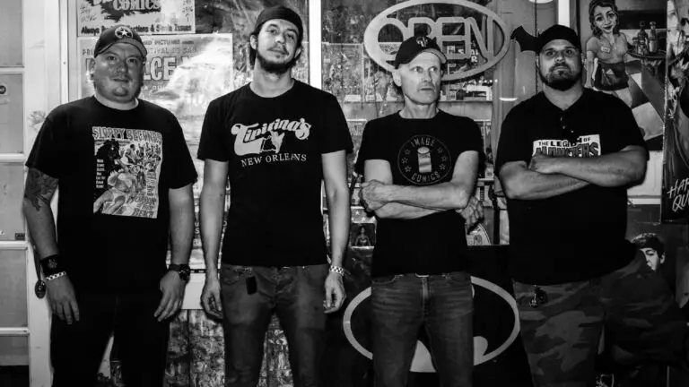 The Queers pose for a press photo inside a comic book store, featuring Joe Queer and bandmates in black t-shirts