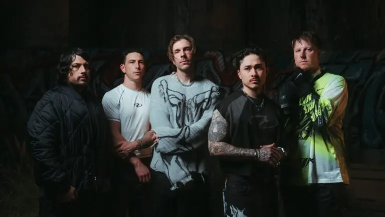 Kingdom of Giants metalcore band press photo, five members posed against a dark graffiti-covered wall