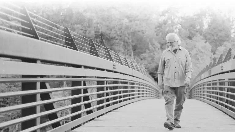 Don Potter walks on a wooden footbridge, musician and guitarist known for creating The Judds' sound