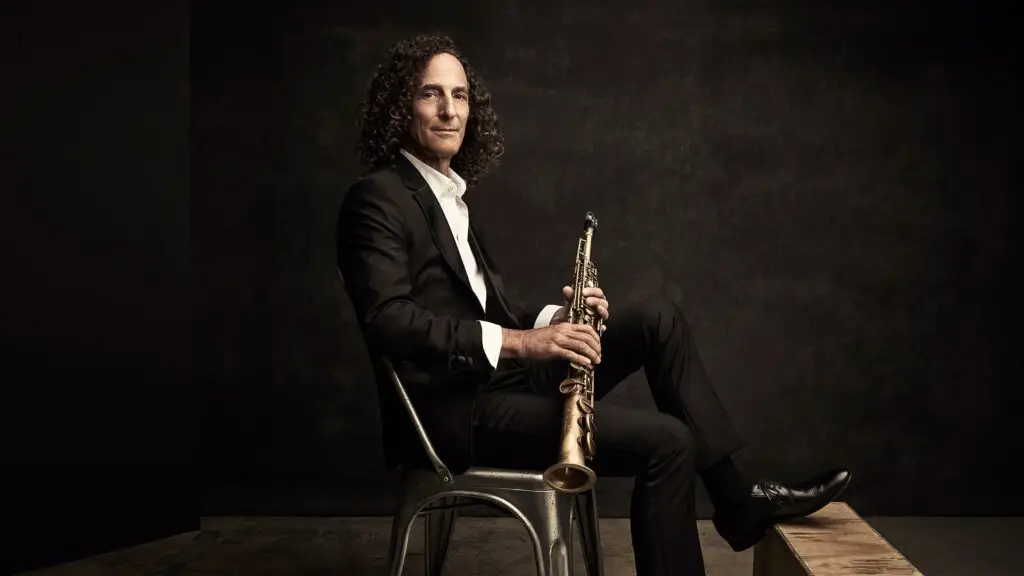 Kenny G seated with soprano saxophone in studio press photo