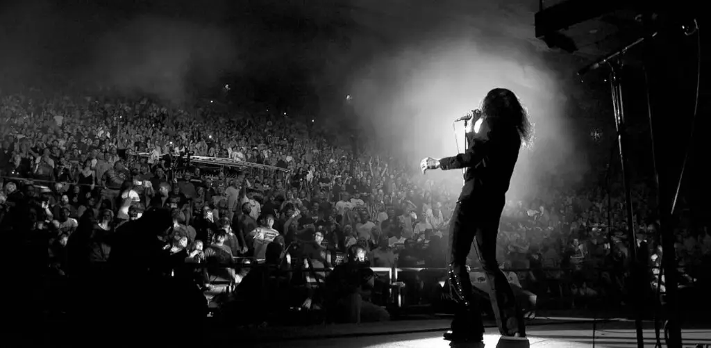 Get the Led Out vocalist performs at Red Rocks Amphitheatre, mic raised to a packed sold-out crowd