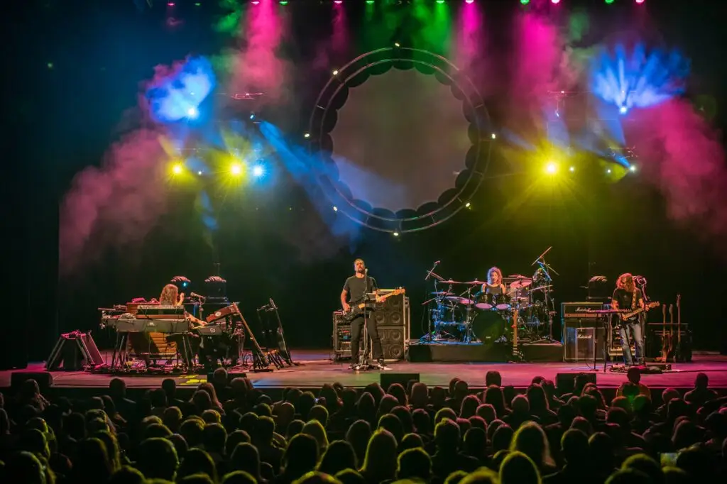 The Machine performing live with theatrical Pink Floyd-style lighting and circular LED ring prop on stage