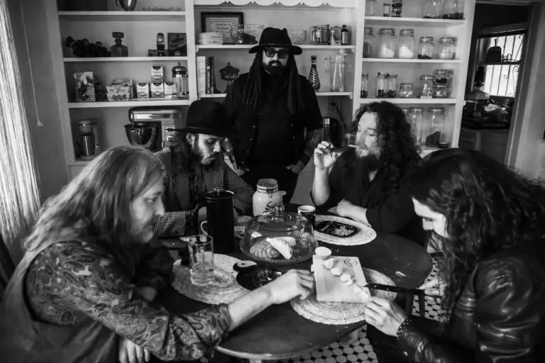 Chest Fever band gathered around a table in a classic rock press photo, black and white