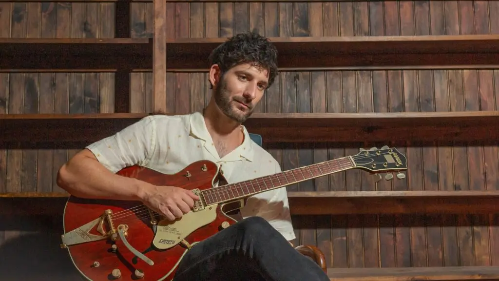 John Splithoff with Gretsch guitar in warm wood-paneled studio setting