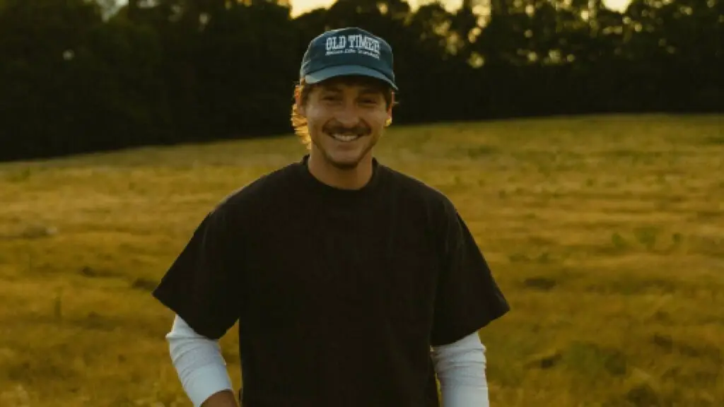 Hunter Flynn in a golden sunlit field at dusk, smiling — Back to My Roots Tour 2026