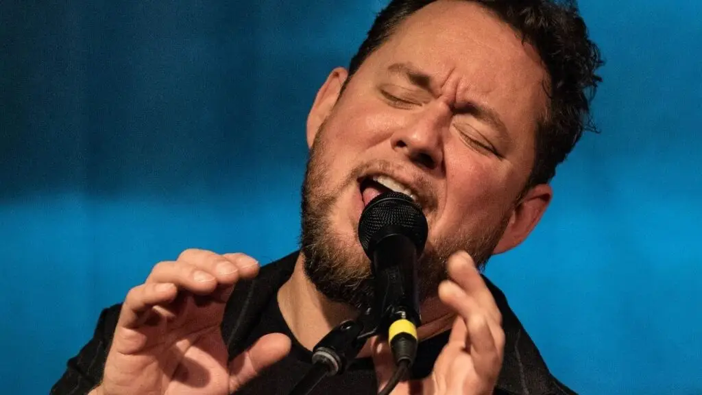 Joey Eppard singing live on stage with intense expression at a microphone