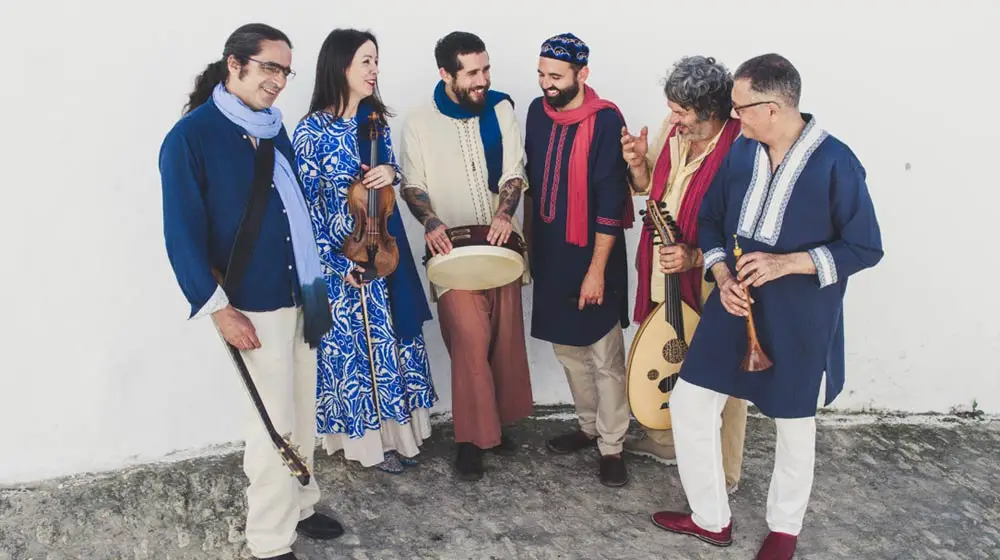 La Banda Morisca six-piece ensemble holding traditional instruments including oud, violin, and frame drum
