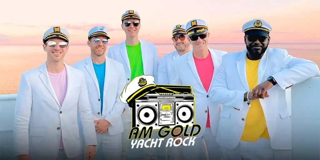 AM Gold Yacht Rock band in captain hats and white suits posing at ocean sunset