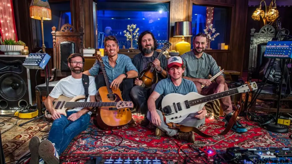 Fireside Collective band members with mandolin, guitar, bass, and drums in a recording studio session