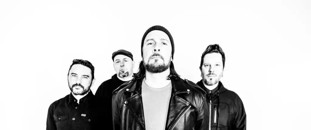 Authority Zero band press photo, four members including frontman Jason DeVore in black and white