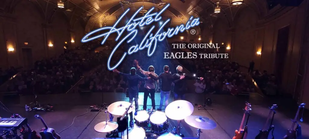 Hotel California Eagles tribute performing live, four members bowing to a packed theater audience