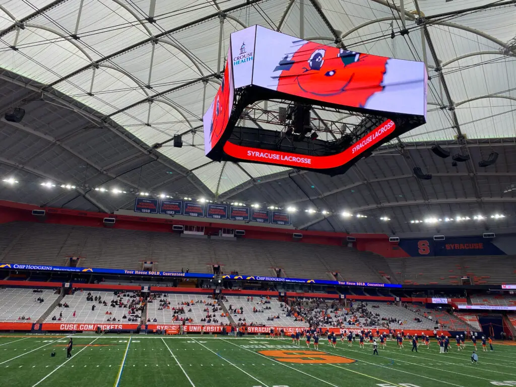 Interior of the JMA Wireless Dome showing the white roof, center-hung video board, and Syracuse seating bowl