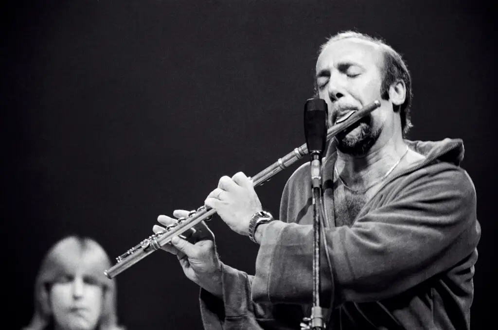 Herbie Mann playing flute into a microphone on stage at the Eastman Theatre in Rochester in 1975