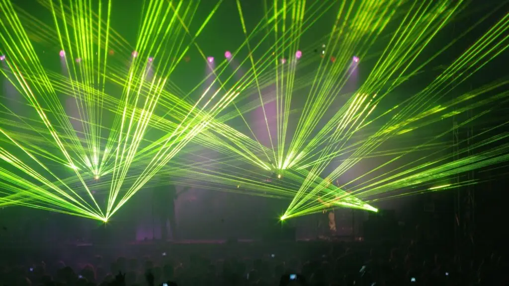 Green laser light show over crowd at a club DJ night